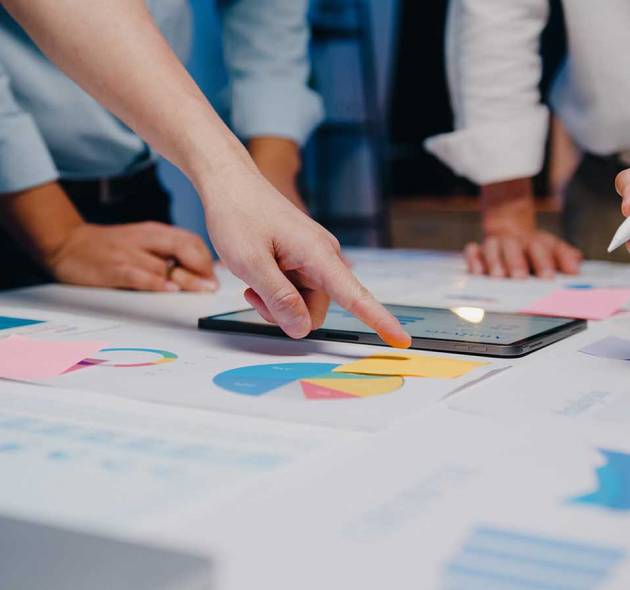 Millennial Asia businessmen and businesswomen meeting brainstorming ideas about new paperwork project colleagues working together planning success strategy enjoy teamwork in small modern night office.